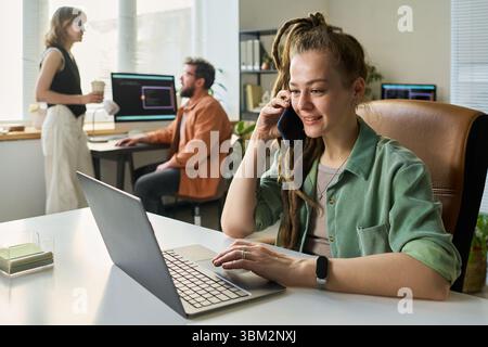 Young Adult Caucasian Woman Developing Neural Network While Talking on Phone Stock Photo