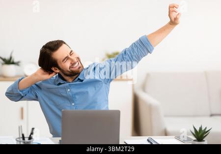 Man Massaging Aching Neck After Work At Computer In Office Stock Photo
