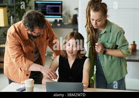 Multiethnic Young Adults Collaborating on Neural Network Development Project Stock Photo