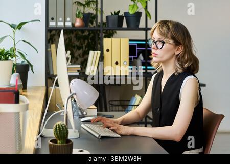 Caucasian Young Adult Woman Developing Neural Network on Desktop Computer Stock Photo
