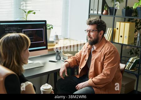 Caucasian Young Adult Man Discussing Neural Network Development with Colleague Stock Photo