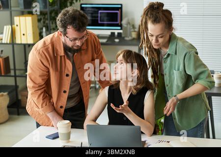 Young Caucasian Woman Discussing Neural Network Development with Colleagues Stock Photo