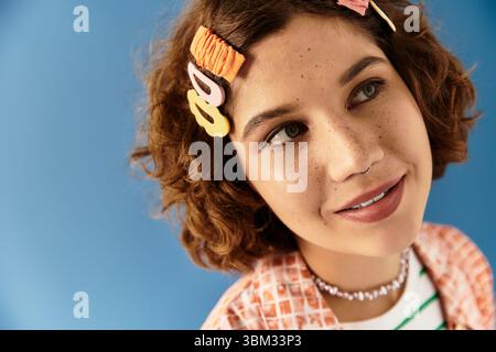 Young woman with short curly hair showcases her vibrant summer outfit, radiating style and joy. Stock Photo