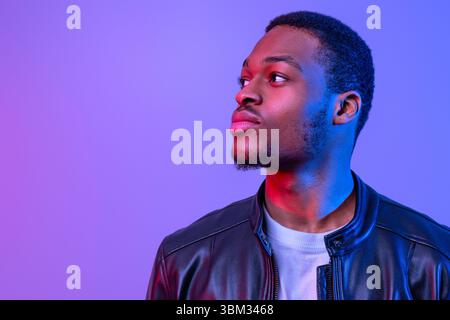 Handsome Young African American Man In Stylish Leather Jacket Looking Aside Stock Photo