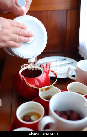 Chinese tea ceremony moment, red teacups and symbolic setup perfect for wedding or family themes Stock Photo