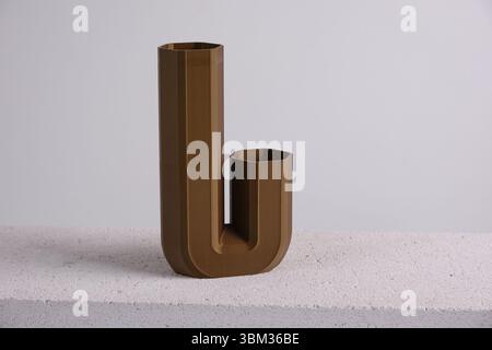 creative 3D printed brown curved vase home decor with a flowing geometric texture Decorative Vase For Dried Flowers made from recycled plastic Stock Photo