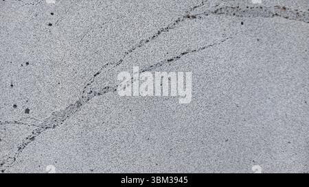 Close-up of a cracked concrete surface with a rough texture Stock Photo