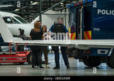 EDITORS NOTE: Image blurred at source. Undated handout photo issued by the Metropolitan Police of James Harding being arrested by officers from the Metropolitan Police following his extradition from Switzerland. A pair of drug kingpins are facing jail for plotting to murder a rival and smuggling millions of pounds worth of cocaine into the UK following one of the largest EncroChat investigations in history. James Harding, 34, and his 'loyal right-hand man' Jayes Kharouti, 39, ran a vast criminal empire which made £5 million in profits from importing drugs over 10 weeks in 2020 alone. Issue dat Stock Photo