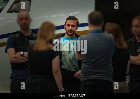 EDITORS NOTE: Image blurred at source. Undated handout photo issued by the Metropolitan Police of James Harding being arrested by officers from the Metropolitan Police following his extradition from Switzerland. A pair of drug kingpins are facing jail for plotting to murder a rival and smuggling millions of pounds worth of cocaine into the UK following one of the largest EncroChat investigations in history. James Harding, 34, and his 'loyal right-hand man' Jayes Kharouti, 39, ran a vast criminal empire which made £5 million in profits from importing drugs over 10 weeks in 2020 alone. Issue dat Stock Photo