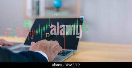 Investment, trading, business analytics, and global financial growth. Person analyzes financial data and stock market graphs on a laptop, with digital Stock Photo
