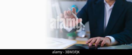 Businessman working at desk using a digital pen and tablet for data analysis, decision-making, business strategy, innovation, financial planning, prod Stock Photo