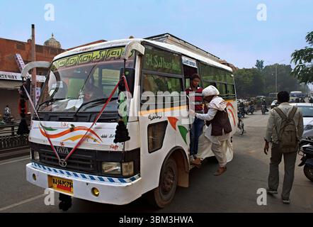 Man jumping on bus in Jaipur, India Stock Photo