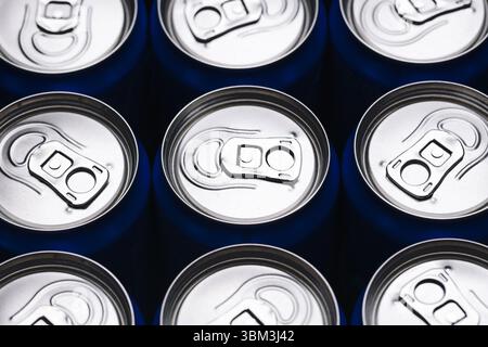 Aluminum drink cans. Top view of silver soda cans. Beverage packaging with metallic shine. Cold refreshing drinks in row. Industrial background. Stock Photo