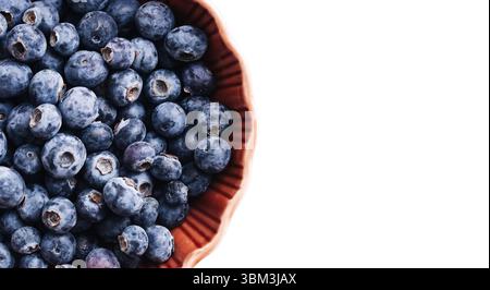 Fresh blueberries in ceramic bowl. Healthy fruit snack with vitamins. White background with copy space. Natural summer harvest. Simple clean isolated. Stock Photo