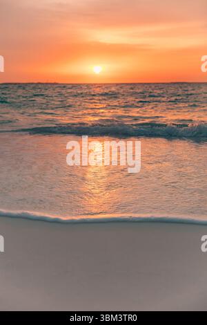 Stunning seaside sunset over calm sea bay waves on horizon under dreamy sky clouds, golden sunlight ocean view summer vacation travel beach background Stock Photo