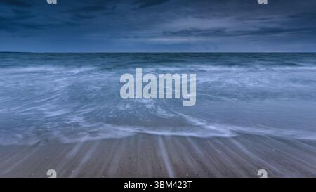 Dynamic Ocean Waves Under a Moody Blue Sky. Stock Photo