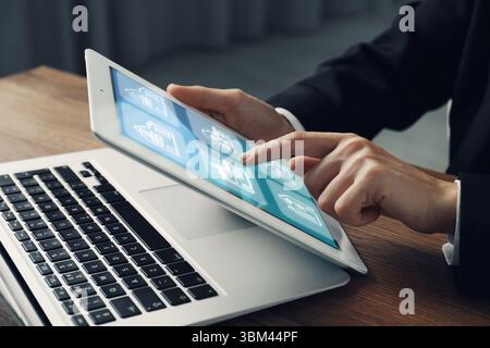 Real estate agent looking for housing via tablet indoors, closeup. Illustrations of buildings on device screen Stock Photo