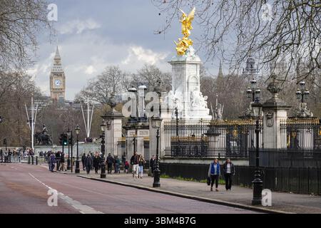 Tourists on Constitution Hill in Green Park, next to Queen Victoria Memorial and the Buckingham Palace in London England United Kingdom UK Stock Photo