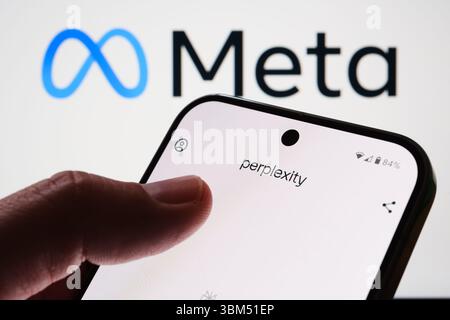 Perplexity interface screen on phone in front of Meta logo with user finger visible. Stafford, United Kingdom, June 24, 2025 Stock Photo