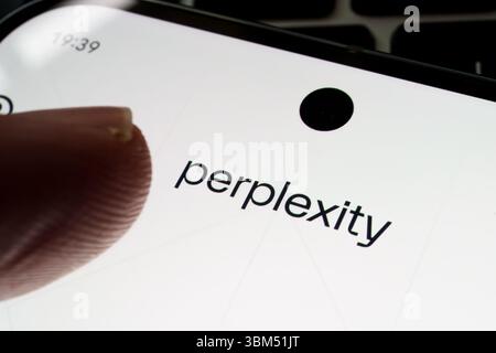 Perplexity AI name on phone screen touched by user’s fingertip in close-up view. Stafford, United Kingdom, June 24, 2025 Stock Photo
