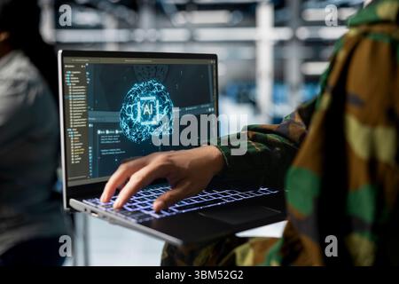 Close up of army tech expert in data center running simulations with military grade defense artificial intelligence. Server farm worker configuring AI dashboards to support mission decisions Stock Photo