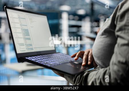 Close up of laptop used by data center software developer to upgrade system stability. Server hub IT professional coding, optimizing performance with device, configuring gear Stock Photo