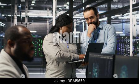 Data center engineers performing maintenance on blade server units used for artificial intelligence processing. IT professionals manage data center arrays used for machine learning training, camera A Stock Photo