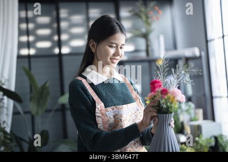 Happy asian female florist Startup small business successful SME in flowers shop Stock Photo