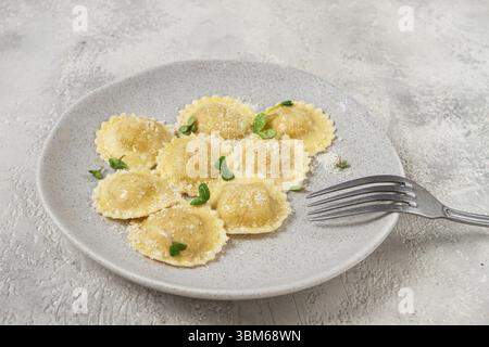 Fresh ravioli with cheese and microgreens, on a black plate, top view ...