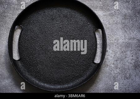 Empty rustic black cast iron plate On a concrete background. Top view with copy space Stock Photo