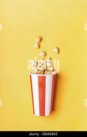 Sweet caramel popcorn in paper striped white red cup Stock Photo