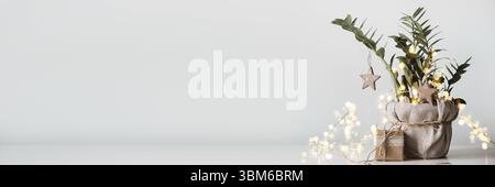 Banner with Christmas tree made from houseplant. Gift boxes packed in paper, decorated with lace and twine. Eco Christmas decor Stock Photo