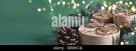 Christmas sustainable round gift boxes and shining garland on green banner. Christmas zero waste Stock Photo