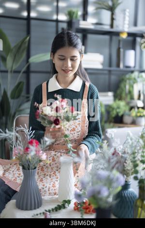 Happy asian female florist Startup small business successful SME in flowers shop Stock Photo