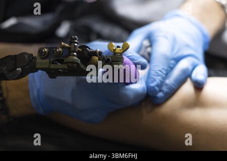 Close-up of an unrecognizable tattoo artist tattooing Stock Photo