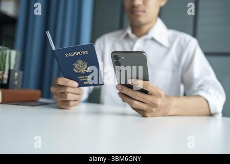 Hand Man Online booking and buying plane tickets using laptop phone and credit card Planning trip travel vacation with passport and ticket Stock Photo