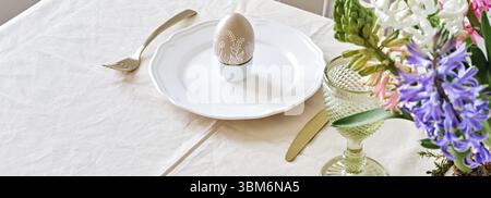 Easter table setting banner with natural Hyacinths flowers. Selective focus, home festive atmosphere Stock Photo