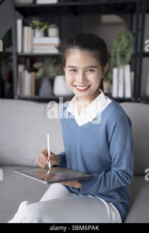 Asian woman Graphic designer working on digital tablet. artist drawing on graphic tablet female Artist Creative Designer sketch graphic drawing creati Stock Photo