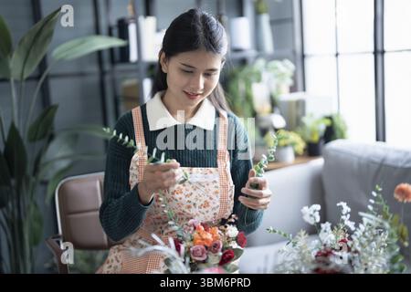 Happy asian female florist Startup small business successful SME in flowers shop Stock Photo