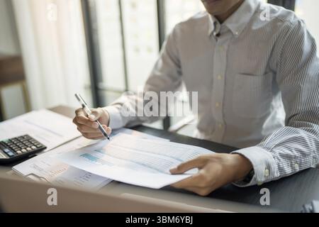 Close up of businessman hands signing or writing document paperwork and report Auditor analysis male professional hand making notes with Business Docu Stock Photo