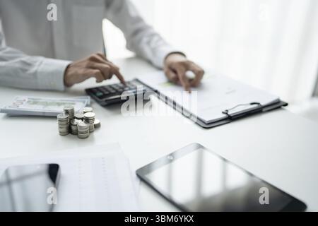 Businessman checking bills taxes bank account balance and calculating annual financial statements of company. Accounting Audit Concept Stock Photo