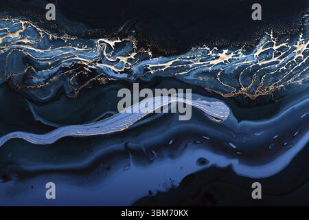 Fluid Art. Liquid Metallic Gold in abstract blue wave. Marble effect background or texture Stock Photo