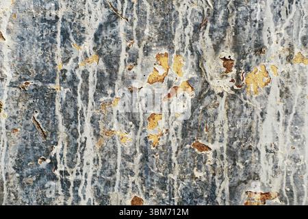 Old and dirty crumbling wall with peeling paint and cracks texture. Grunge interior background closeup Stock Photo