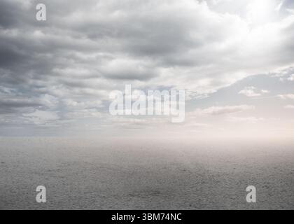 Open sea surface is reflecting gentle ripples in flat design with overcast sky and warm glow Stock Photo