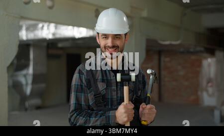 Funny man builder engineer dancing repairman industry building construction smiling guy in hard hat male technician handyman successful architect Stock Photo
