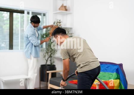 Home Cleaning and Bonding. Two friends working together to tidy their living space with joy. Stock Photo