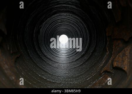 Light at the end of a dock tunnel as concept of hope, focus and perspective Stock Photo