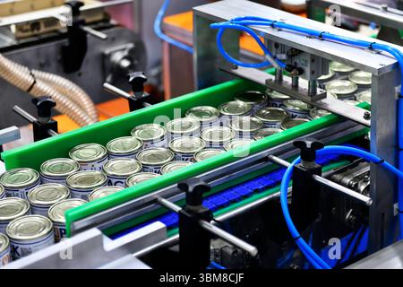 Bangkok, Thailand-June13, 2025: Canned food products on conveyor belt in distribution warehouse.food transportation system concept in Propak asia at B Stock Photo