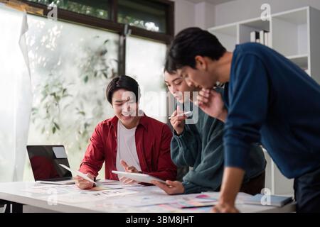 Creative Collaboration in UIUX. Diverse team members engaging in design discussions over project materials. Stock Photo