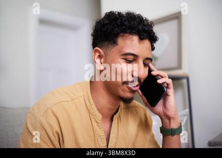 Man Relaxing at Home While Engaged in a Phone Conversation Stock Photo